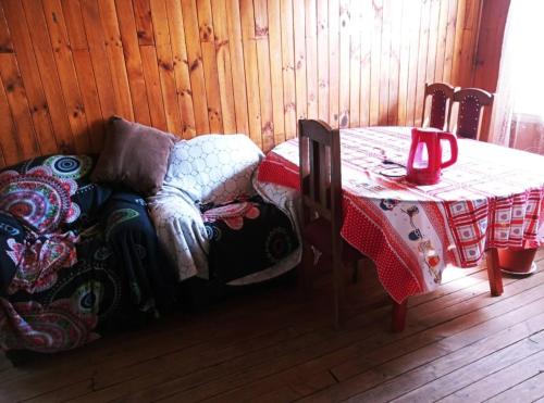 Habitación con mesa, silla, mesa y mesa con mesa en Cabaña Payun, en Lonquimay