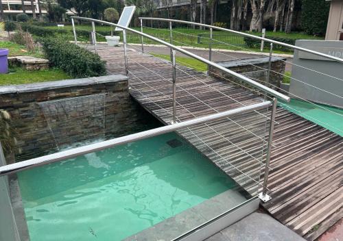 un grand bassin d'eau avec une balustrade métallique autour de celui-ci dans l'établissement Azur Évasion Meublé Classé 3 etoiles Croisette Festival Residence Grand Hôtel, à Cannes