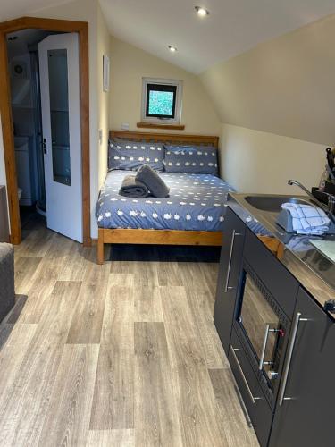 a small bedroom with a bed and a kitchen at Morvan Pod in Fort William