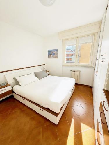 a bedroom with a white bed and a window at Luminoso, Versilia, Vicino al Mare in Marina di Carrara