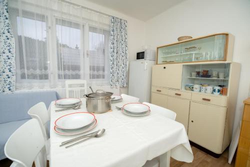 カロリンカにあるDům u splavuのキッチン(白いテーブル、食器付)
