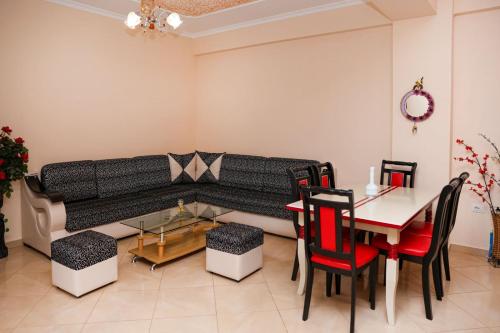- un salon avec un canapé, une table et des chaises dans l'établissement Rio's Apartment, à Berat