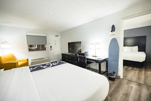 a hotel room with a large bed and a desk at La Quinta Inn by Wyndham Tampa Near Busch Gardens in Tampa