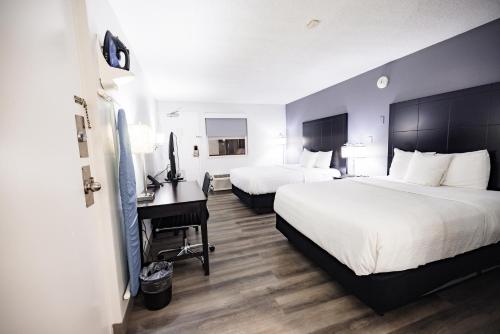 a hotel room with two beds and a desk at La Quinta Inn by Wyndham Tampa Near Busch Gardens in Tampa