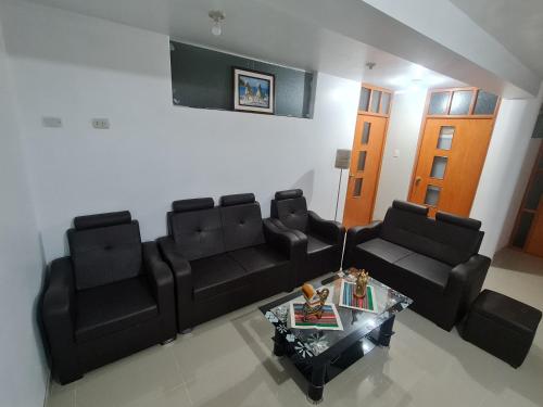 sala de estar con sofás de cuero negro y mesa de centro en Wilder host, en Puno
