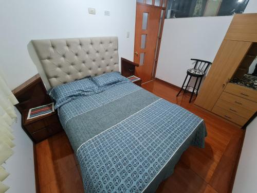 sypialnia z łóżkiem z niebieską kołdrą w obiekcie Wilder host w mieście Puno