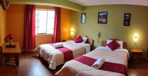 a hotel room with two beds and a window at Krusty Hostel B&B in Huaraz