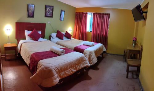 a hotel room with two beds with red curtains at Krusty Hostel B&B in Huaraz