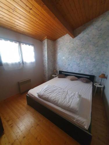 une chambre avec un lit et un plafond en bois dans l'établissement Charmante maison proche plage - 5242, à Soulac-sur-Mer
