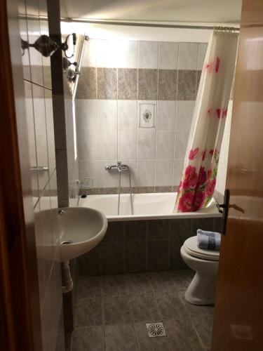 een badkamer met een bad, een wastafel en een toilet bij Blue Sky Apartments I in Makry Gialos