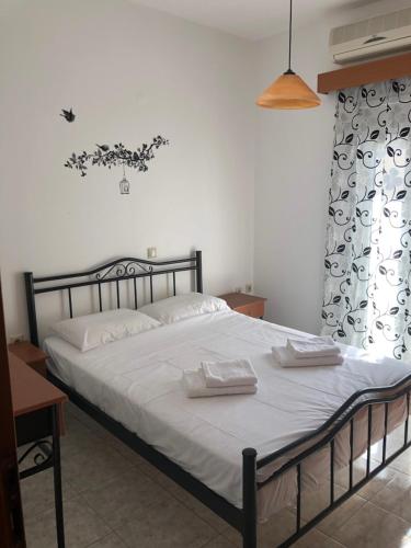 een slaapkamer met een bed met twee handdoeken erop bij Blue Sky Apartments I in Makry Gialos