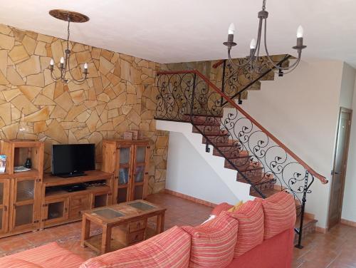 a living room with a staircase and a tv at Jaye’s Home in Arona