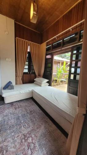 a bedroom with two beds and a large window at Rumah Seraya@Zaki’s Residence, Marang, Terengganu in Marang