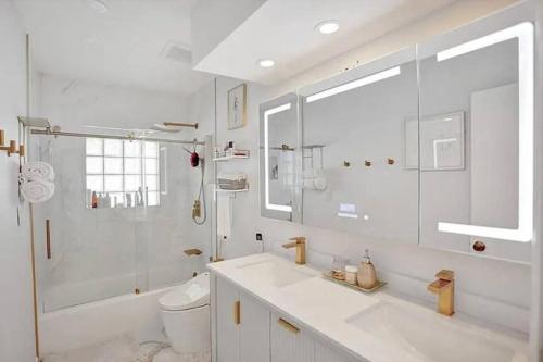 a bathroom with a sink and a shower and a toilet at Stylish palm beach home with pool and office in Palm Beach Gardens