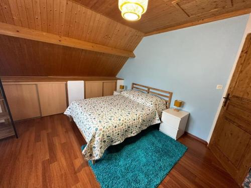 a bedroom with a bed and a blue rug at La Maison Verte in Clécy