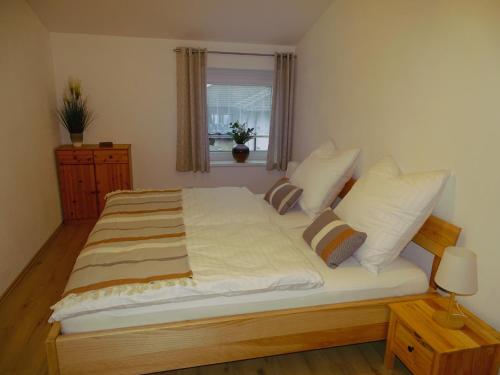 a bedroom with a large bed with white sheets and pillows at Ferienwohnung Schusternagerl in Simbach