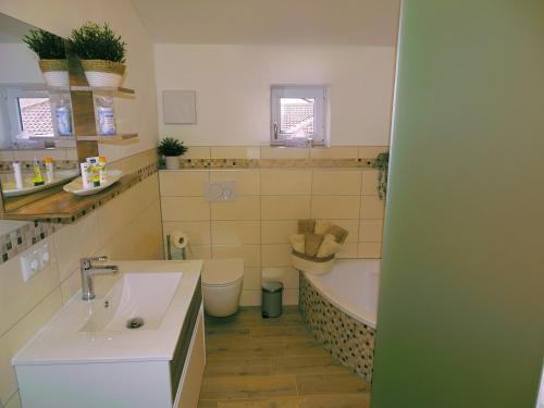 łazienka z umywalką, wanną i toaletą w obiekcie Ferienwohnung Schusternagerl w mieście Simbach