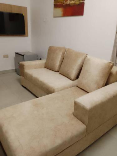 ein Wohnzimmer mit einem Sofa und einem Flachbild-TV in der Unterkunft Zek’s Place in Ikeja
