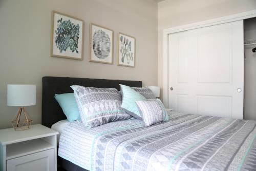 a bedroom with a bed with blue and gray pillows at Queen Anne Retreat - 1 Blk from CPA - Free Parking in Seattle