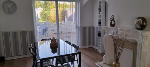 a living room with a table and chairs and a clock at Ladbury House in Walsall near M6, Walsall Uni and Hospital, with free parking and easy access to Birmingham city centre and West Bromwich, only 20 mins to NEC and Birmingham airport, 15 mins to Villa Park, Great for contractors! in Bescot