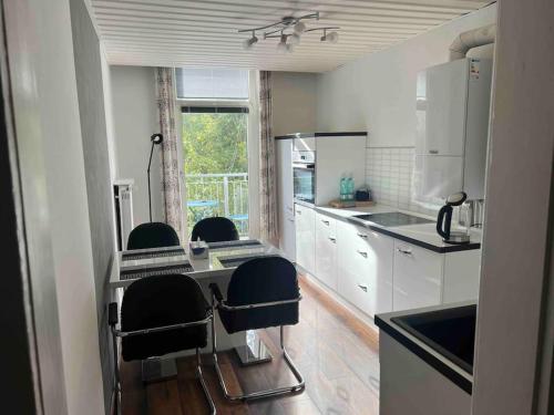 eine Küche mit weißen Schränken und schwarzen Stühlen in der Unterkunft Wohnung im Zentrum 70 qm in Hof