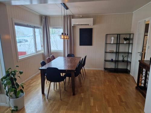 a dining room with a wooden table and chairs at Semi-detached house downtown in Tromsø