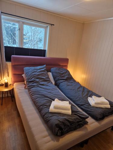 a bed with two towels on it in a room at Semi-detached house downtown in Tromsø