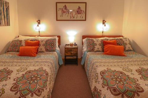 een slaapkamer met 2 bedden en oranje kussens bij Jewett's Gem in East Jewett