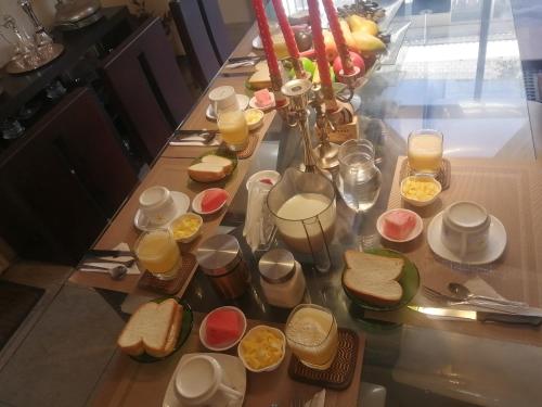 a long table with plates of food and glasses of orange juice at FAKALI Homestay in Quito