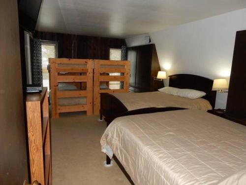 1 dormitorio con 2 camas y TV de pantalla plana en The Retreat, 