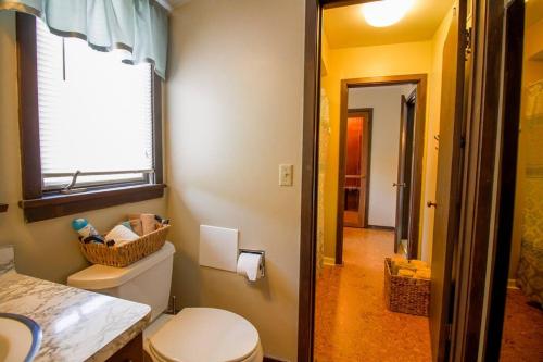 baño con aseo, ventana y pasillo en The Retreat, 