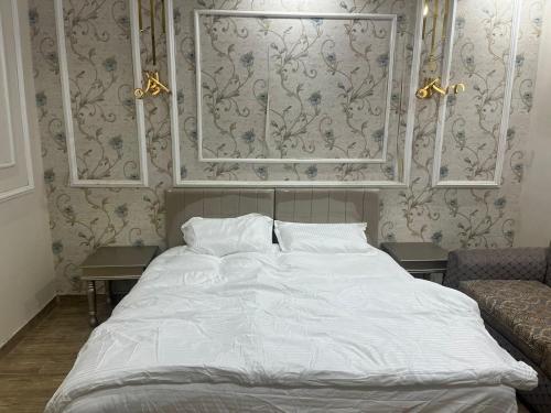 a bedroom with a large white bed and a couch at شالية سحاب in Medina