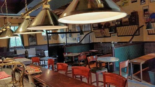 a restaurant with tables and chairs and pendant lights at Château de la Grange Fort in Issoire