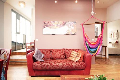 - un salon avec un canapé rouge et un hamac dans l'établissement Exotic Loft in Montmartre + terrace !, à Paris