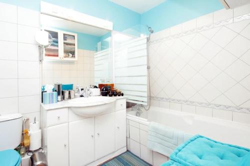 La salle de bains blanche est pourvue d'un lavabo et d'une baignoire. dans l'établissement Exotic Loft in Montmartre + terrace !, à Paris