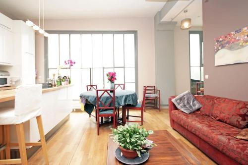un salon avec un canapé rouge et une table dans l'établissement Exotic Loft in Montmartre + terrace !, à Paris