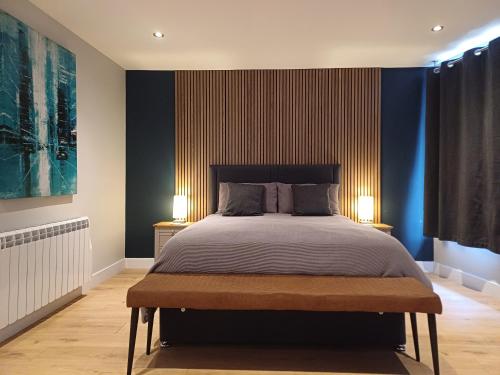 1 dormitorio con 1 cama grande y paredes azules en The Old Warehouse Ely "Apartments", en Ely