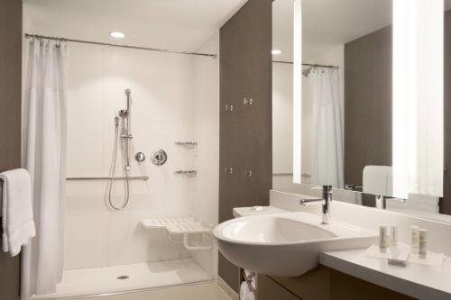 uma casa de banho branca com um lavatório e um chuveiro em SpringHill Suites by Marriott Allentown Bethlehem/Center Valley em Center Valley