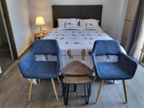 a bedroom with two blue chairs and a bed at Puerto Malabrigo, Plaza de Armas (Chicama, Peru) in Puerto Chicama