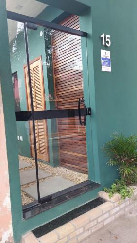 a front door of a house with a wooden door at Morada do Sol Suítes in Arraial do Cabo