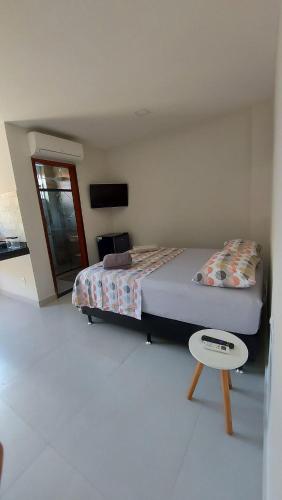 a bedroom with a bed and a table in it at Morada do Sol Suítes in Arraial do Cabo