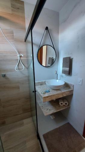 a bathroom with a sink and a mirror at Morada do Sol Suítes in Arraial do Cabo