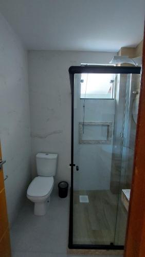 a bathroom with a toilet and a glass shower at Morada do Sol Suítes in Arraial do Cabo