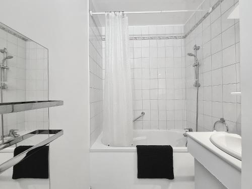 Baño blanco con bañera y lavamanos en L'Artiste, en Soisy-sous-Montmorency