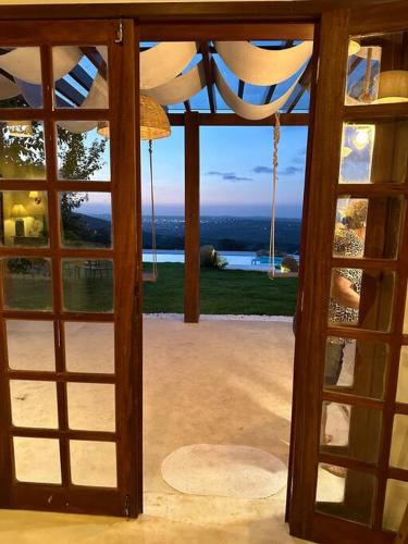 an open door to a house with a view of the ocean at Casa Pedra da Lua, uma casa para contemplar o agreste. in Gravatá