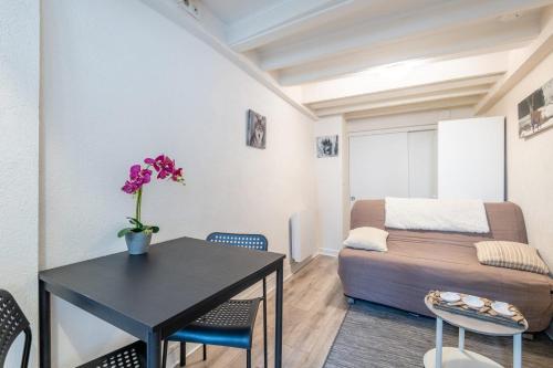 un salon avec une table et un canapé dans l'établissement Paquier Studio - at the gates of the old town, à Annecy