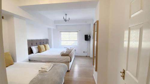 Cette chambre comprend un lit, un canapé et une fenêtre. dans l'établissement UK CHAPS Retreat: 2 Bedroom - 2Bathroom Apartment, à Londres
