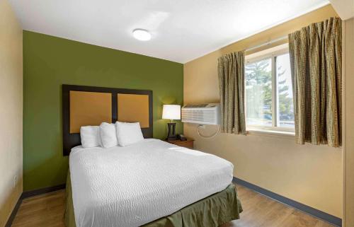 - une chambre avec un lit aux murs verts et une fenêtre dans l'établissement Extended Stay America Select Suites - St Louis - Westport - Craig Road, à Maryland Heights