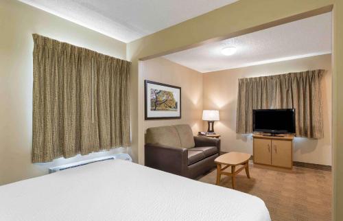 a hotel room with a bed and a chair and a television at Extended Stay America Suites - Knoxville - West Hills in Knoxville