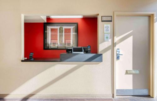 een wachtkamer met een kassa en een rode muur bij Extended Stay America Select Suites - Cincinnati - Florence - Meijer Dr in Florence